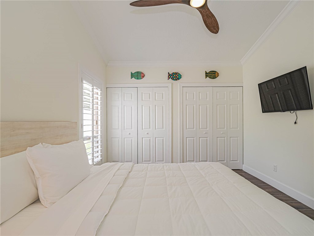 5101 Florida A1A, Unit 7 Vero Beach, FL 32963 - Photo 28 of 35 a bedroom with a bed and a flat screen tv