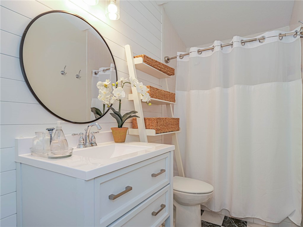 5101 Florida A1A, Unit 7 Vero Beach, FL 32963 - Photo 29 of 35 a bathroom with a sink mirror and toilet