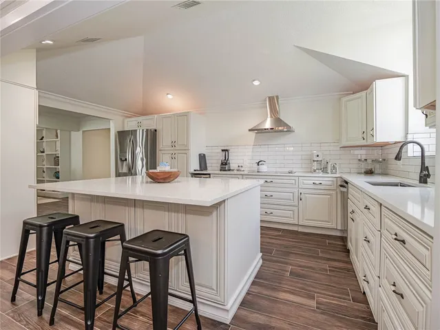 a kitchen with a table chairs sink and cabinets