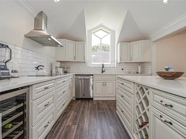 a kitchen with cabinets wooden floor and a window