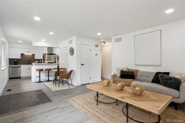 a living room with furniture and view of kitchen