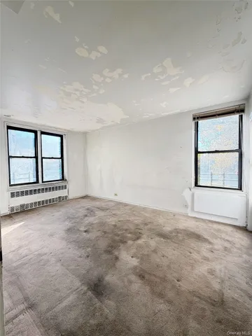 a view of a big room with wooden floor and brick walls