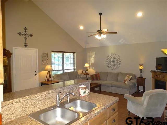 a living room with furniture a chandelier and a dining table with wooden floor