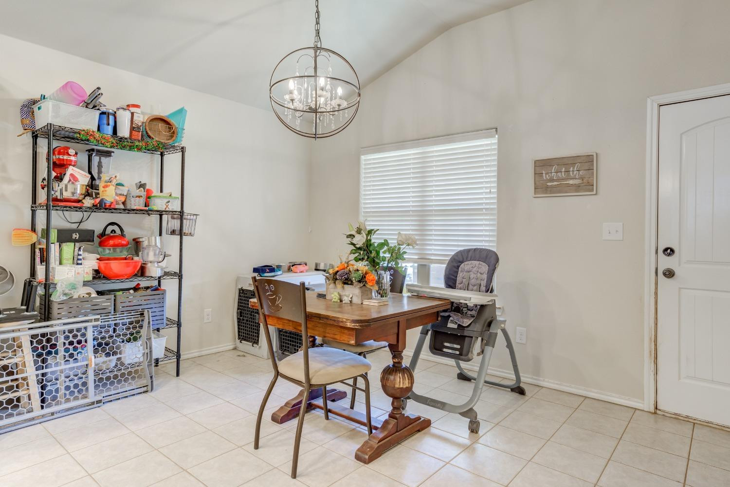 5725 110th Street Lubbock, TX 79424 - Photo 11 of 24 a view of a dining room with furniture and chandelier