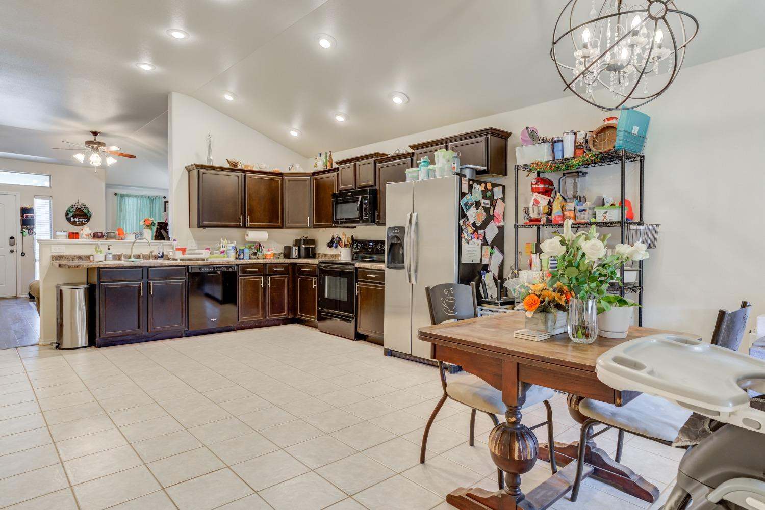 5725 110th Street Lubbock, TX 79424 - Photo 12 of 24 a kitchen with stainless steel appliances a table and chairs in it