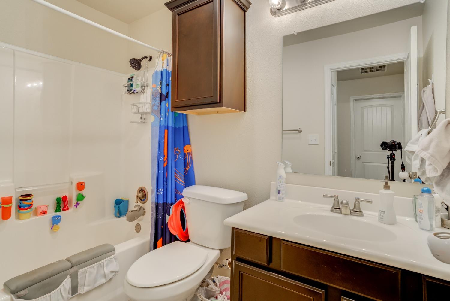 5725 110th Street Lubbock, TX 79424 - Photo 13 of 24 a bathroom with a sink a toilet and a mirror