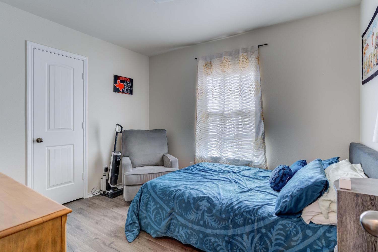 5725 110th Street Lubbock, TX 79424 - Photo 14 of 24 a bedroom with a bed and wooden floor