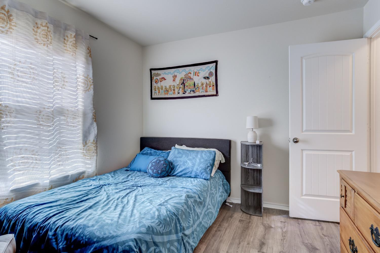 5725 110th Street Lubbock, TX 79424 - Photo 15 of 24 a bedroom with a bed and wooden floor