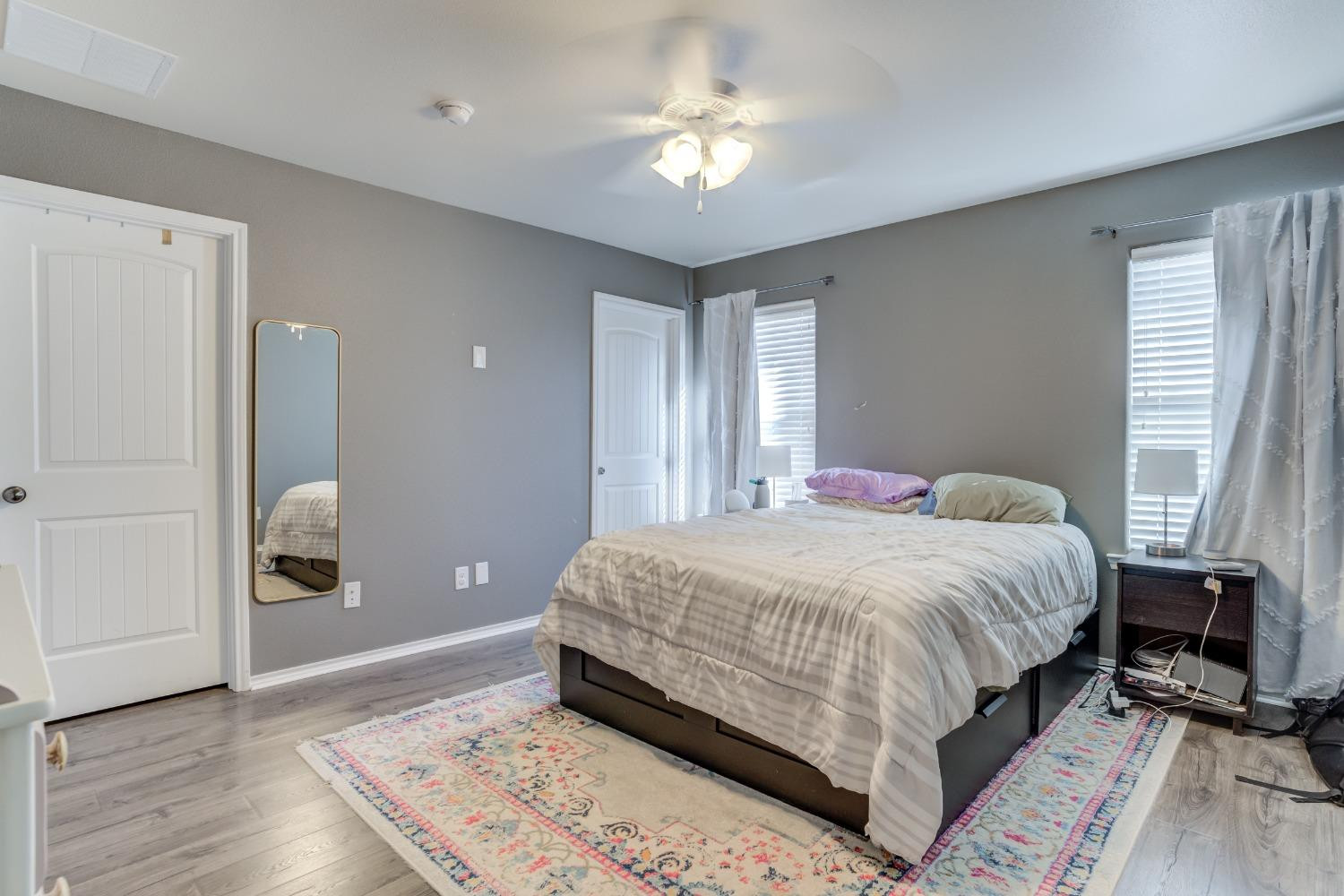 5725 110th Street Lubbock, TX 79424 - Photo 19 of 24 a bedroom with a large bed and a chandelier