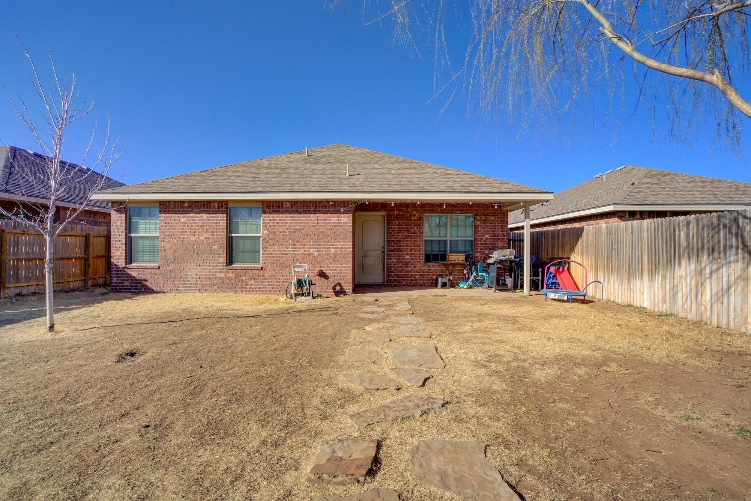 5725 110th Street Lubbock, TX 79424 - Photo 24 of 24 a front view of a house with a yard and garage