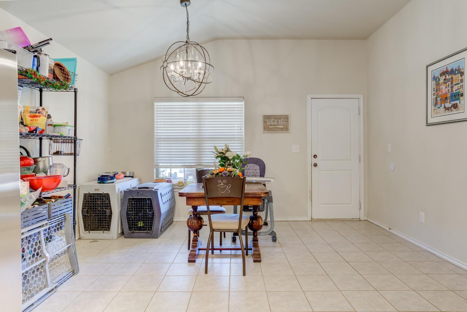 5725 110th Street Lubbock, TX 79424 - Photo 10 of 24 a view of a dining room with furniture and chandelier