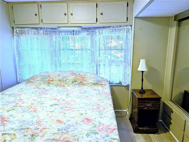 a bed sitting in a kitchen next to a cabinet
