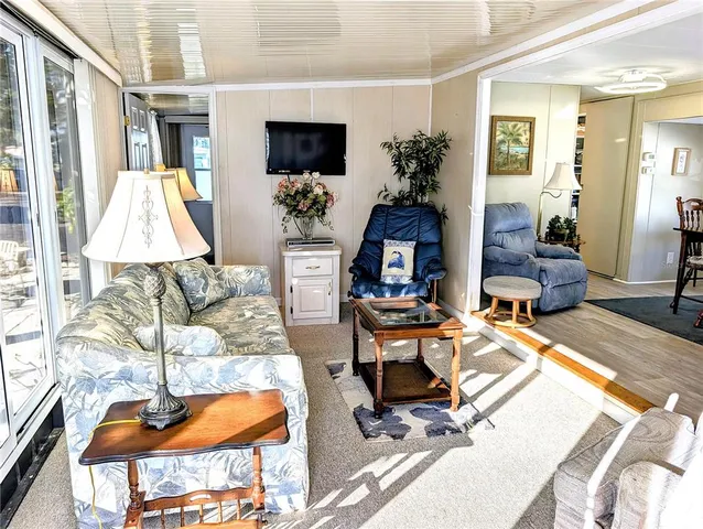 a living room with patio furniture and a flat screen tv