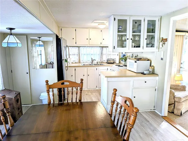 a kitchen with stainless steel appliances granite countertop a table chairs and a refrigerator