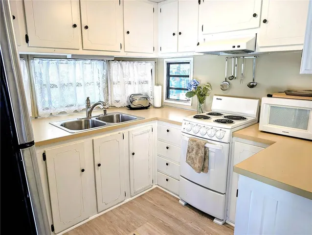 a kitchen with white cabinets and appliances