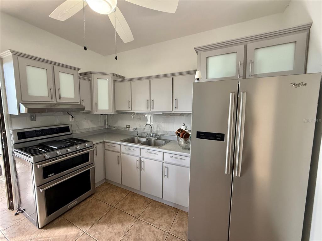 411 Bo Calvache Rincon, PR 00677 - Photo 6 of 14 a kitchen with stainless steel appliances white cabinets and a refrigerator