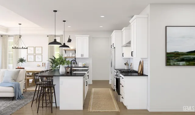 a view of kitchen with kitchen island stainless steel appliances kitchen island granite countertop a stove a sink a refrigerator and a dining table with wooden floor