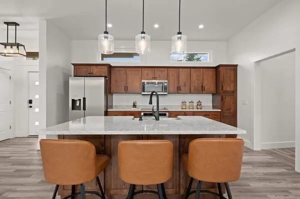 a kitchen with stainless steel appliances granite countertop a refrigerator and a stove top oven