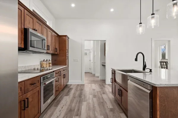a kitchen that has a sink a microwave oven a counter space and wooden floor