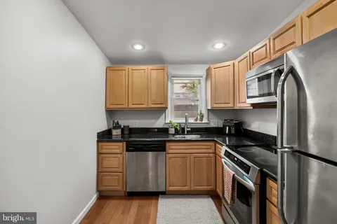 a kitchen with stainless steel appliances granite countertop a stove a refrigerator and a sink