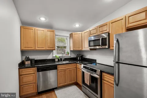 a kitchen with stainless steel appliances granite countertop a refrigerator a stove top oven a sink and dishwasher
