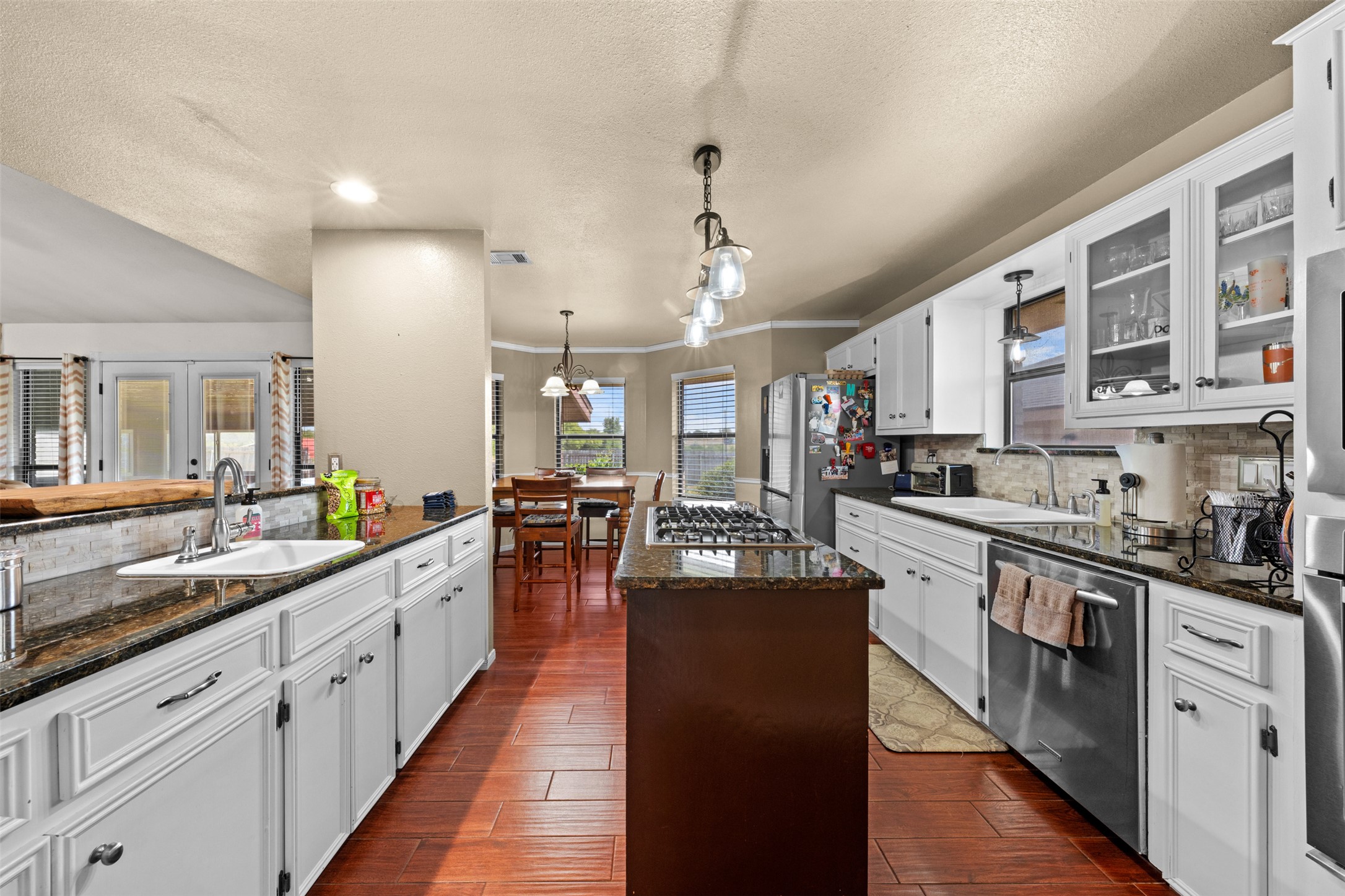 1512 Panther Loop Pflugerville, TX 78660 - Photo 24 of 40 An inviting kitchen with rich wood flooring flows into a bright dining area, perfect for daily meals.