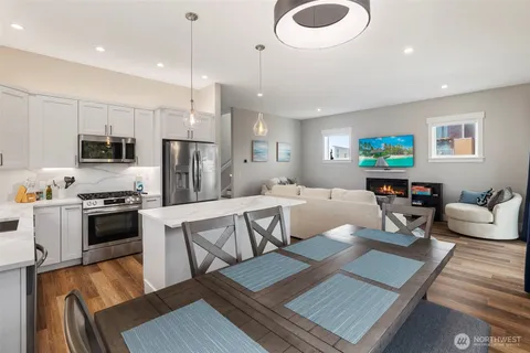 a kitchen with stainless steel appliances granite countertop a refrigerator a sink dishwasher a stove and a refrigerator