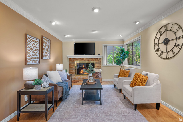 1726 Wasatch Boulevard Sandy, UT 84092 - Photo 4 of 38 Living area featuring a brick fireplace with a white mantel, recessed lighting, and crown molding