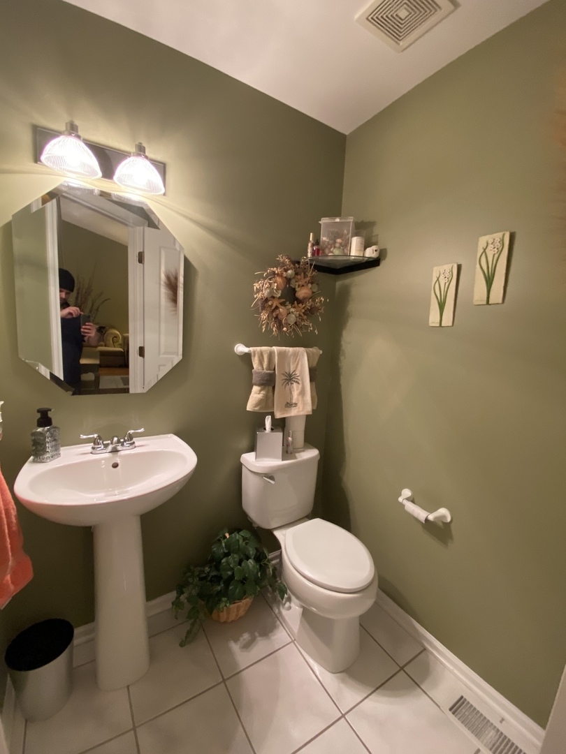 418 Cardinal Drive Bartlett, IL 60103 - Photo 5 of 29 a bathroom with a toilet sink and mirror