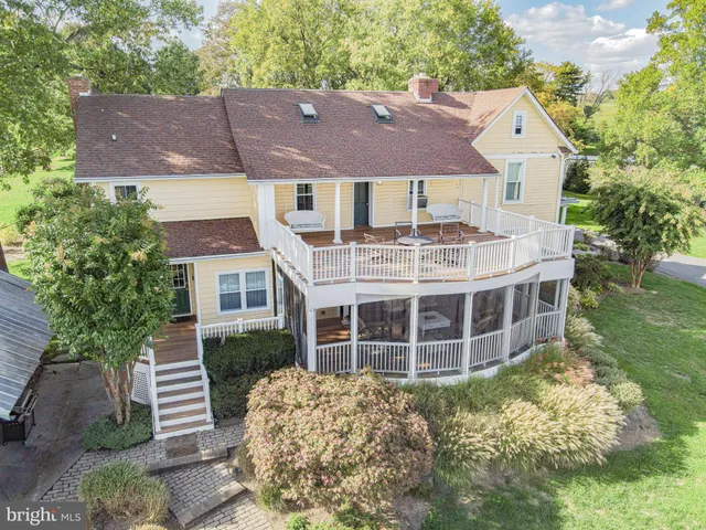 a front view of a house with a yard and potted plants