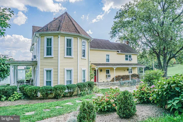 a kitchen with stainless steel appliances granite countertop a stove a refrigerator a sink a dining table and chairs with wooden floor