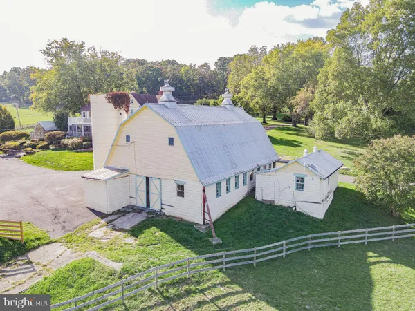 a front view of a house with a yard and large trees