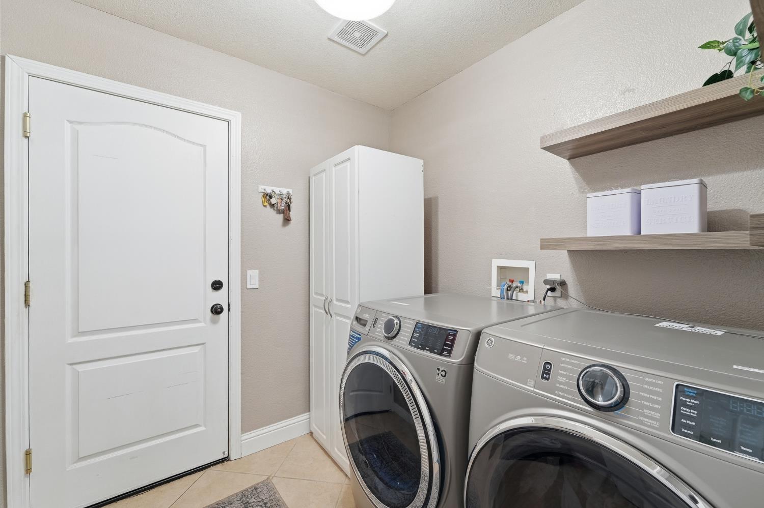 2220 Ellison Drive Modesto, CA 95355 - Photo 38 of 53 a view of washer and dryer with kitchen in the background