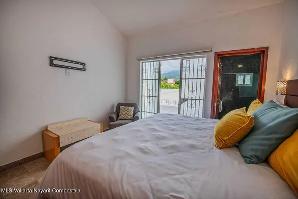 a bedroom with a bed dresser and a window