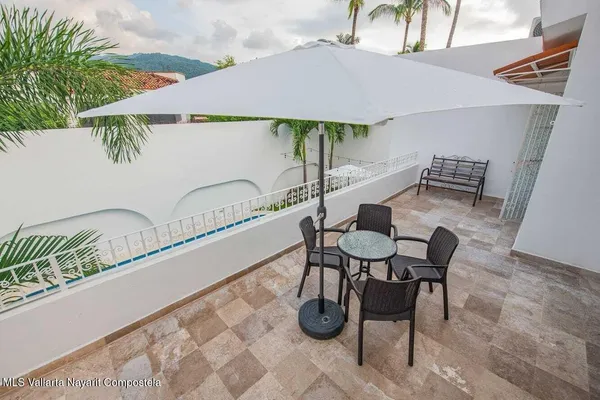 a balcony with table and chairs