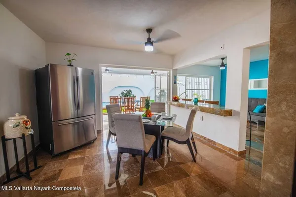 a kitchen with stainless steel appliances a refrigerator a stove a dining table and chairs