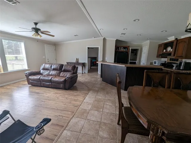 a living room with furniture a flat screen tv and kitchen view