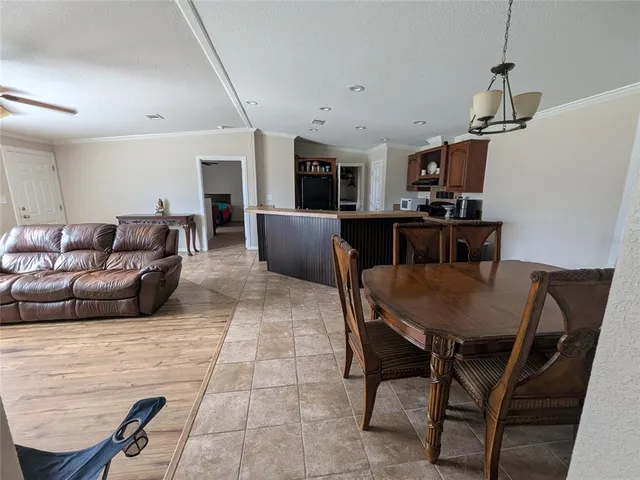 a living room with furniture a flat screen tv and kitchen view