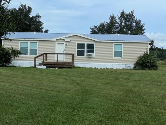 a front view of house with a garden and trees
