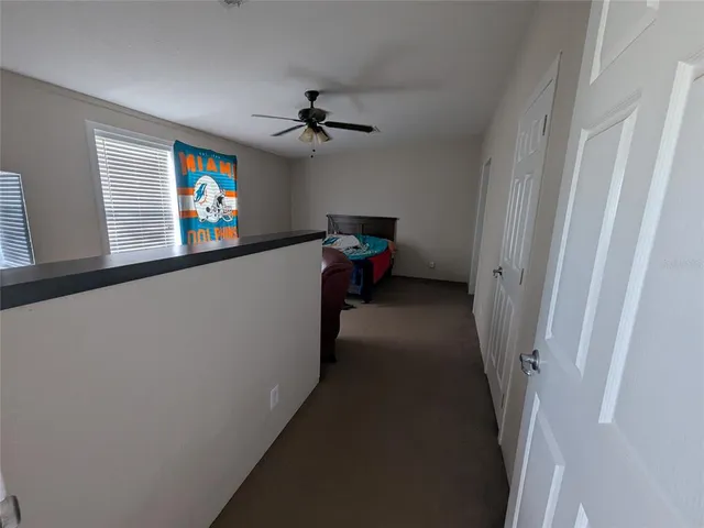 a view of hallway with furniture and a flat screen tv