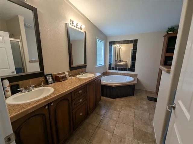 a bathroom with a double vanity sink a mirror and a toilet