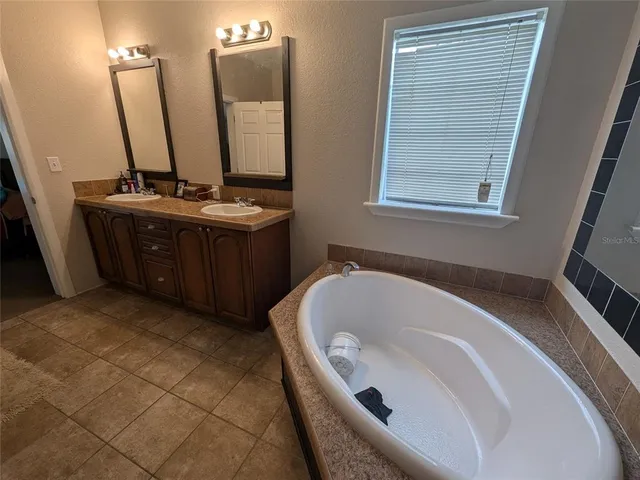 a bathroom with a tub sink and mirror