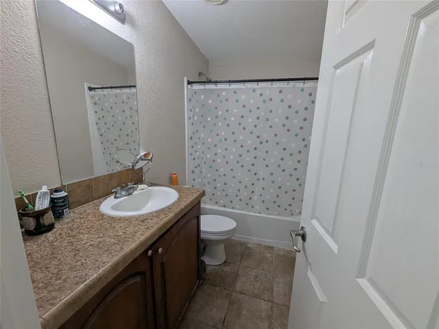 a bathroom with a granite countertop sink toilet and a mirror