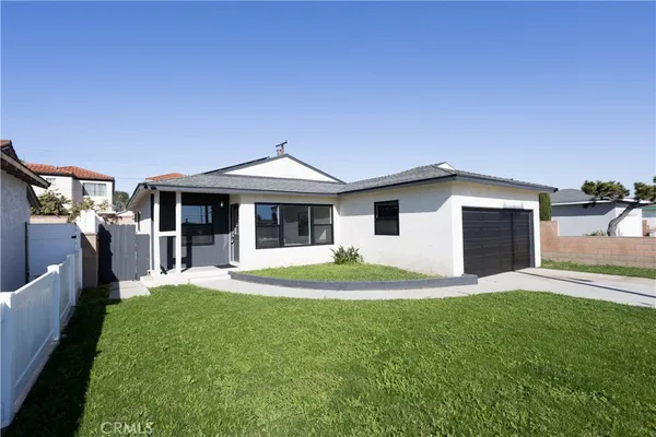 a front view of a house with a yard and trees