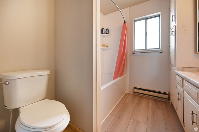 285 West 600 North, Unit 2 Logan, UT 84321 - Photo 16 of 21 Bathroom featuring a white toilet, shower-tub combination, and wood-finish flooring
