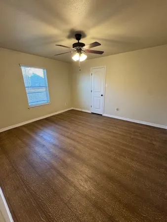 a view of an empty room with a ceiling fan and a window