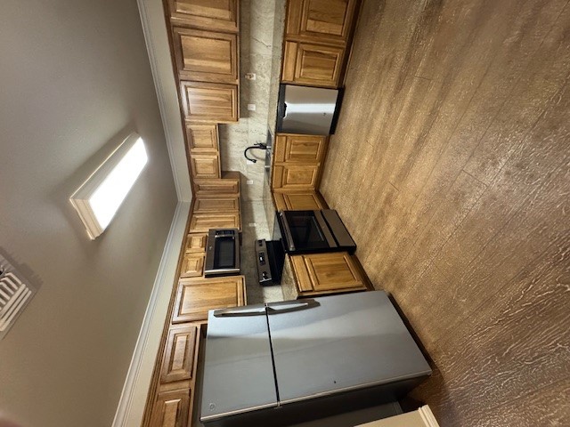 101 Calvin Smith Ln., Unit B Jarrell, TX 76537 - Photo 7 of 33 Kitchen with stainless steel appliances, ornamental molding, wood finished cabinets, wood like finished floors, and tasteful backsplash