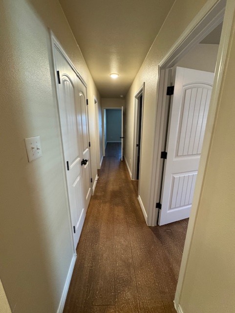 101 Calvin Smith Ln., Unit B Jarrell, TX 76537 - Photo 10 of 33 Hallway featuring baseboards and wood like floors! This leads to all bedrooms and bathrooms!