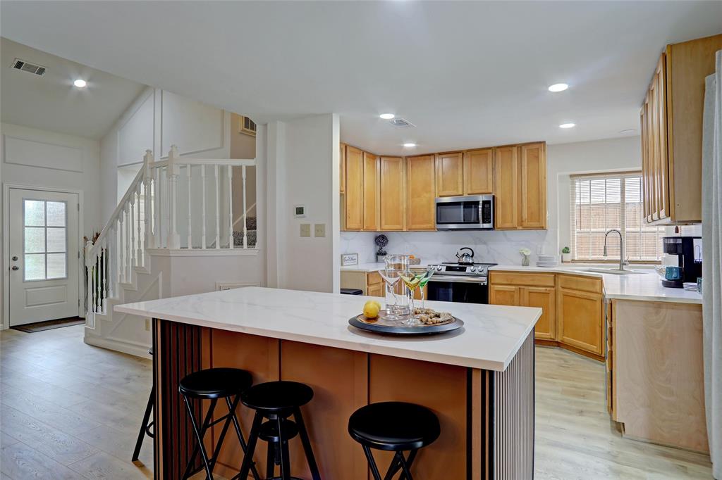 3411 Beech Street Rowlett, TX 75089 - Photo 9 of 32 a kitchen with a dining table chairs and microwave