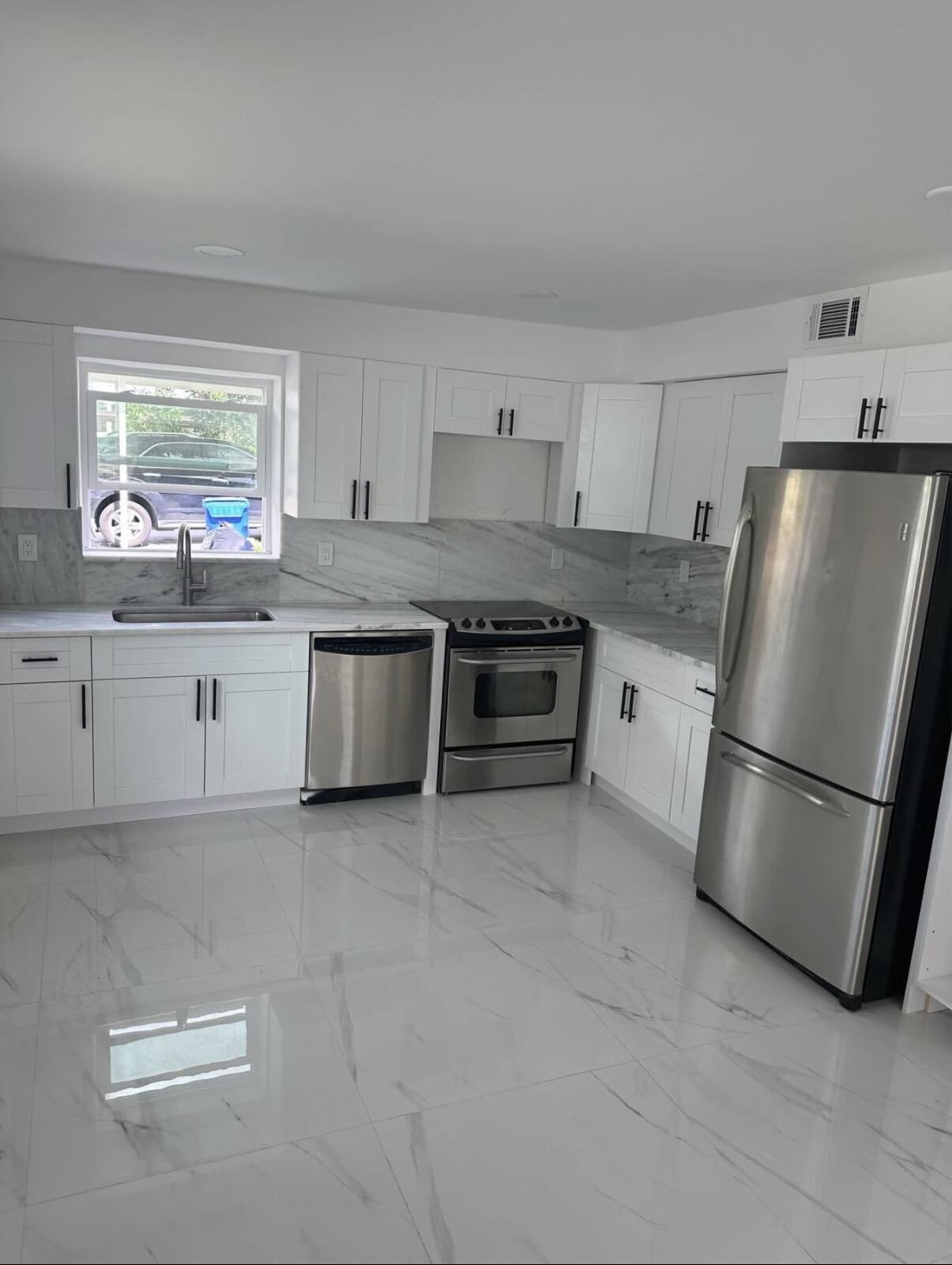 a kitchen with stainless steel appliances granite countertop a refrigerator sink and stove